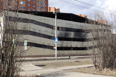 Yangından sonra çok katlı otopark. İçinde yanmış arabalar ile kopya-karanlık pencereler