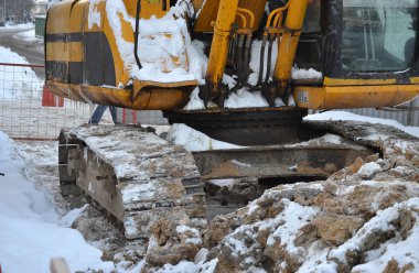 Ekskavatör kapatın. Kışın sokakta tamir işleri. Rusya.