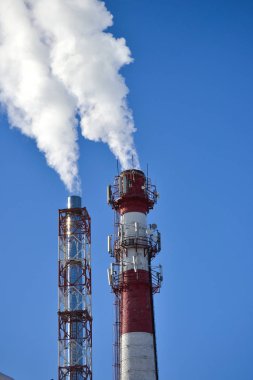 İki boru. Gökyüzüne karşı bir bacadan endüstriyel duman