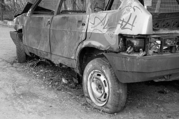 Verlaten verbrand personenauto in de buurt van het appartementencomplex. Rusland. Monochrome afbeelding — Stockfoto