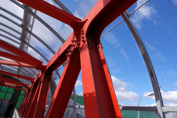 Steel beams in red against a blue sky. Overhead passage. Industrial background — Stock Photo, Image