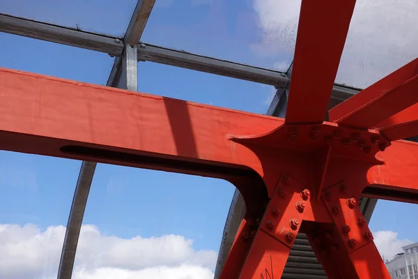 Stalen balken in rood tegen een blauwe lucht. Overhead passage. Industriële achtergrond — Stockfoto