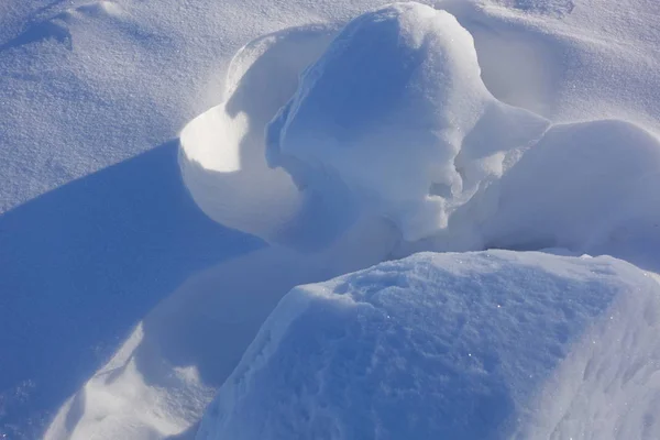 Winterhintergrund. Abstrakt. Schneeverwehungen. fließende Übergänge von Licht- und Schattenlinien. Schnee an einem sonnigen Tag. — Stockfoto