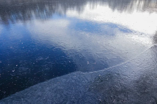 Modrý LED na povrchu lesního jezera. Sníh ještě nepadl. Časné zimy — Stock fotografie