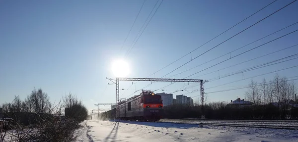 Paysage hivernal Le soleil bas et froid illumine le chemin de fer enneigé. Le train de marchandises va à Moscou. Russie . — Photo