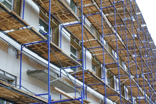 Steigers rond een hoogbouw. Reparatiewerkzaamheden. Renovatie van het gebouw — Stockfoto