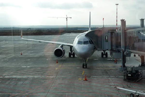O lado da frente da aeronave e um corredor fechado se aproxima da aeronave para carregar passageiros. Aeroporto de Simferopol. 2019 01 de janeiro — Fotografia de Stock