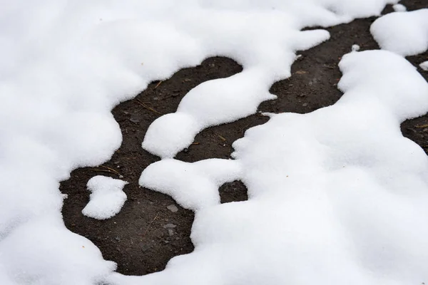 Winter background. The snow is melting and looking through the ground. — Stock Photo, Image