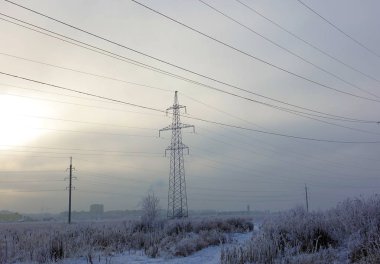 Winter. Frosty landscape. Transmission tower or electricity pylon to support an overhead power line. Russia.