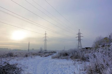 Winter. Frosty landscape. Transmission tower or electricity pylon to support an overhead power line. Russia.