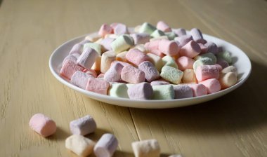 Beyaz tabakta çok renkli marshmallowlar.