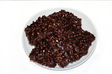 Beyaz arka plan üzerinde izole beyaz yuvarlak plaka üzerinde fındık ile Çikolata kare çerez