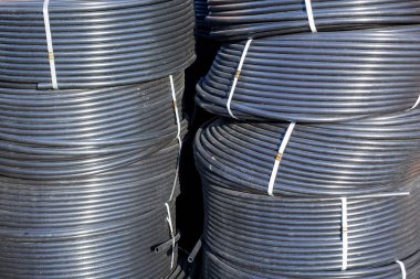Açık havada saklanan sarmal siyah plastik borular