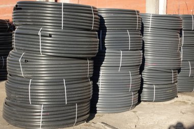 Açık havada saklanan sarmal siyah plastik borular
