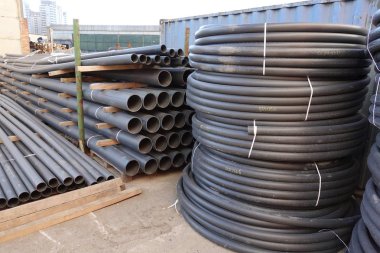Açık havada saklanan sarmal siyah plastik borular