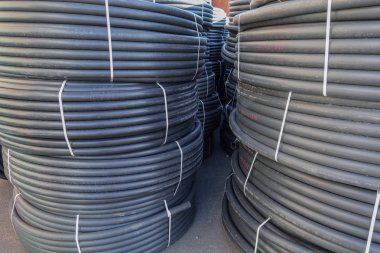 Açık havada saklanan sarmal siyah plastik borular