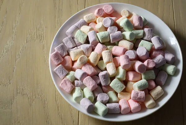 Beyaz tabakta çok renkli marshmallowlar. — Stok fotoğraf