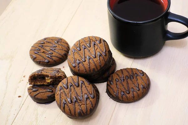 チョコレートは、コーヒーを入れた木製のテーブルの上にクッキーを覆いました。朝食。デザート. — ストック写真