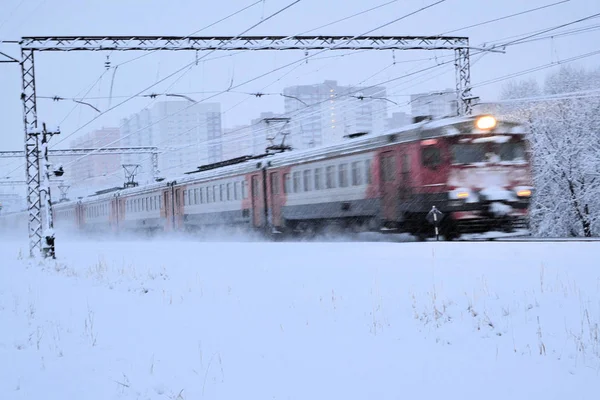 Electric train goes on railway route. Train transports passengers. Winter travel trip. Russia