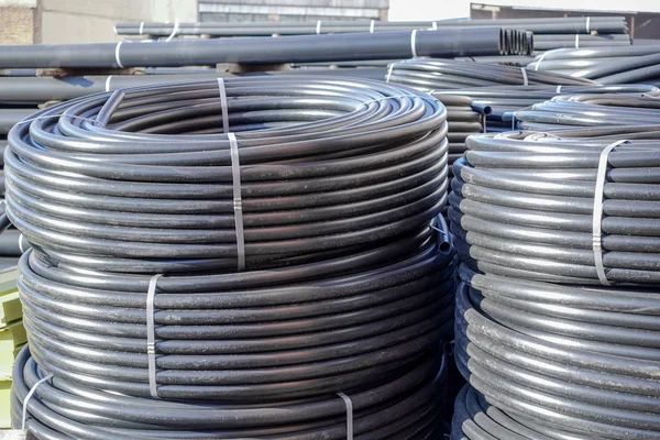 Açık havada saklanan sarmal siyah plastik borular
