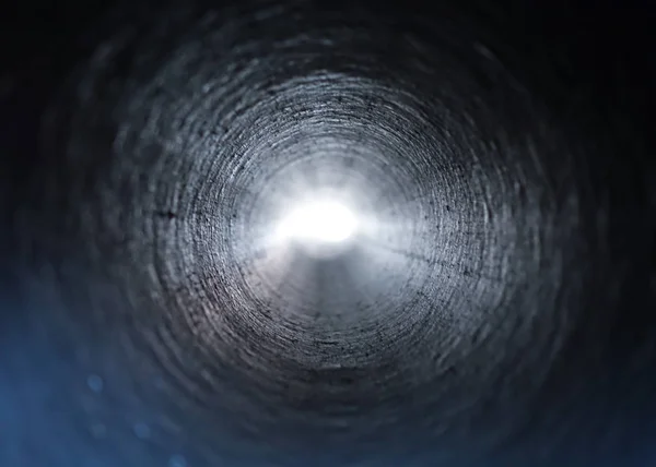 Inside view of a round plastic pipe. Tunnel to the light from the dark — Stock Photo, Image