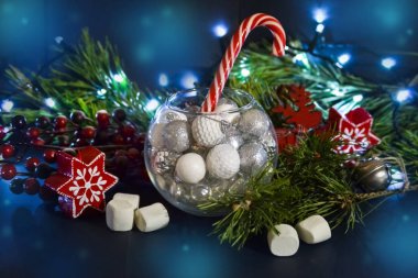 Yuvarlak bir cam güzel Noel süslemeleri. Ladin dalları, ışık. Mumlar, şekerlemeler. Yeni yıl kompozisyonu.