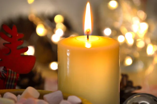 Eine Kerze, die hell in der Dunkelheit vor dem Hintergrund verschwommener Lichter brennt. Romantik, festlicher Abend — Stockfoto