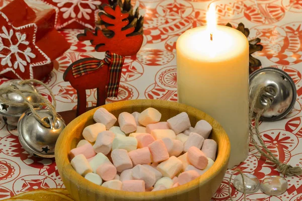 Marshmallow i en trä tallrik. Tända ljus på bordet. Nyårs komposition — Stockfoto