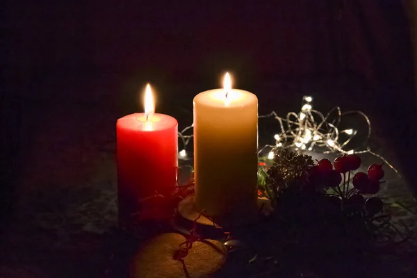 Weihnachtskomposition: rot-weiße brennende Kerzen auf einem festlichen Tisch vor dunklem Hintergrund. Lebkuchen, Lametta, Girlanden. Weihnachten, Neujahr, Feiertag — Stockfoto