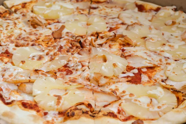 Big pineapple pizza cut into pieces