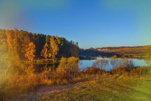 Осенний пейзаж с красочным лесом. Красочная листва над озером с красивыми лесами в красном и желтом цветах. Осенний лес отражается в воде. старый фотоэффект — стоковое фото