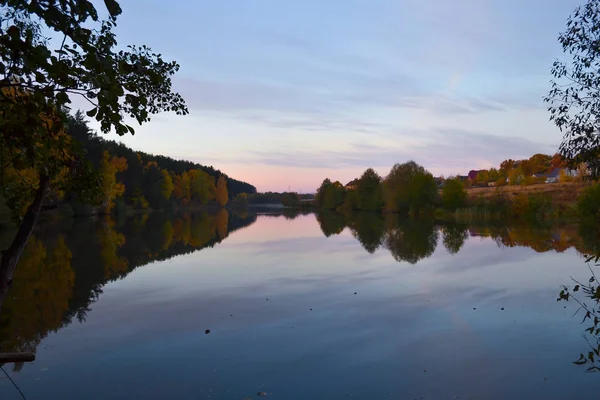 Morgendämmerung im Wald am See. Der Wald spiegelt sich im Wasser. Herbst am frühen Morgen. Russland — Stockfoto