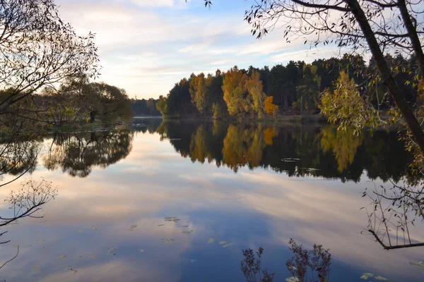 Morgendämmerung im Wald am See. Der Wald spiegelt sich im Wasser. Herbst am frühen Morgen. Russland — Stockfoto