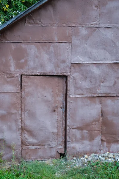 Parede de folhas de ferro. A porta é forrada com folhas de ferro. Textura de fundo — Fotografia de Stock