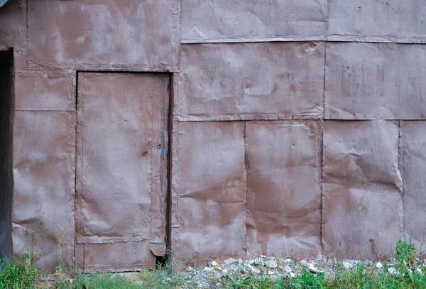 Parede de folhas de ferro. A porta é forrada com folhas de ferro. Textura de fundo — Fotografia de Stock