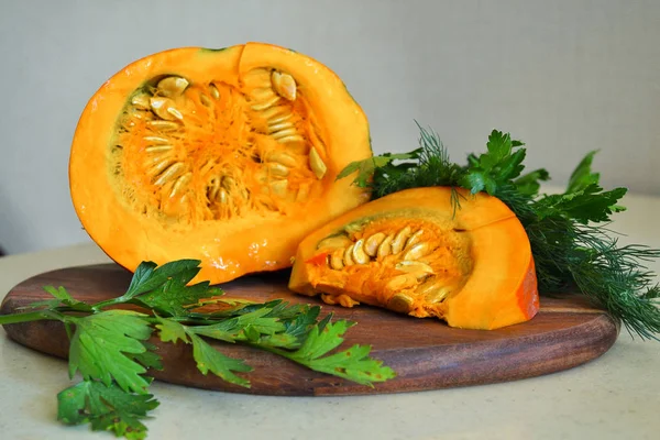 Calabaza fresca de naranja, con verduras. cortar rebanadas de calabaza en la mesa —  Fotos de Stock