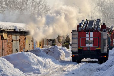Itfaiye. İtfaiye arabası ve itfaiyeciler iş başında. Çok duman var. Kış mevsimi. Rusya