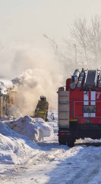 Itfaiye. İtfaiye arabası ve itfaiyeciler iş başında. Çok duman var. Kış mevsimi. Rusya