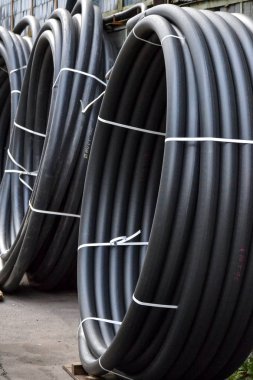 Açık havada saklanan sarmal siyah plastik borular