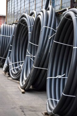 Açık havada saklanan sarmal siyah plastik borular