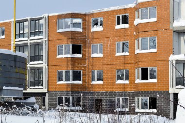 Çok katlı bir binanın terk edilmiş inşaatı. Kule vinç ve kırık camlı bir ev. Kış. Rusya