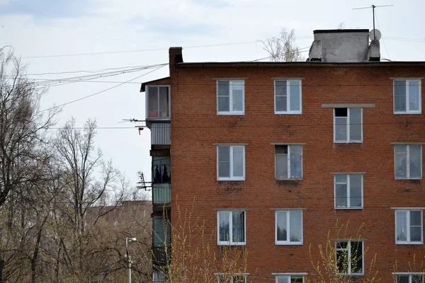 Fotografie starého poschoďového bytový dům v nedostatečně rozvinutém regionu Ukrajiny nebo Ruska. Zastaralá vícepodlažní budova (Hostel) na pozadí oblačné oblohy — Stock fotografie