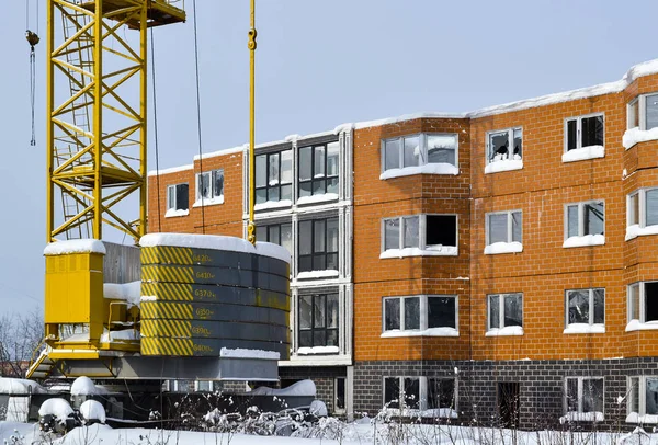 Verlaten bouw van een gebouw met meerdere verdiepingen. Torenkraan, en een huis met gebroken glas. Winter. Rusland — Stockfoto