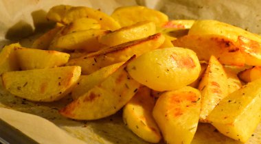 Fırında patates dilimleri fırında kağıt üzerinde. Close