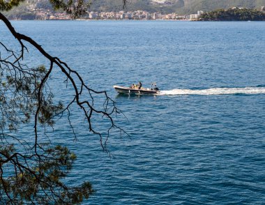 Deniz manzarası. Motorlu tekne de suda insanlar var. Dağdan manzara. Adriyatik