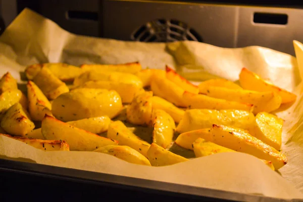 Batata cozida cunhas no forno em assar papel. Close-up — Fotografia de Stock