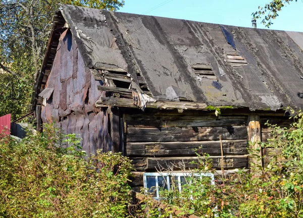 Oude instortende zwarte schuur met een lekkerig dak — Stockfoto