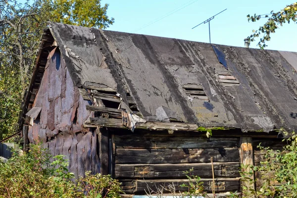 Velho celeiro preto em colapso com um telhado vazado — Fotografia de Stock
