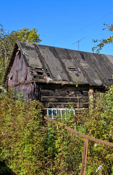 Velho celeiro preto em colapso com um telhado vazado — Fotografia de Stock