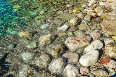 Deniz manzarası. Suda kıyı renkli taşlar. Adriyatik Denizi